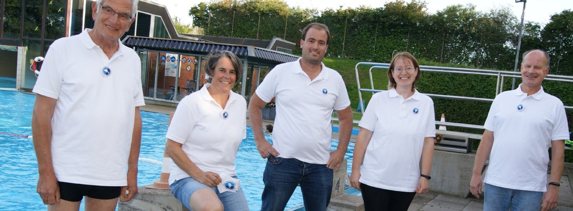 Drei Männer und zwei Frauen stehen vor einem Schwimmbecken