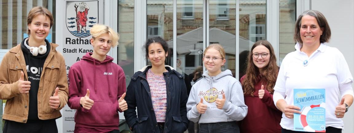 Fünf Schülerinnen und Schüler und eine Frau stehen vor dem Kappelner Rathaus
